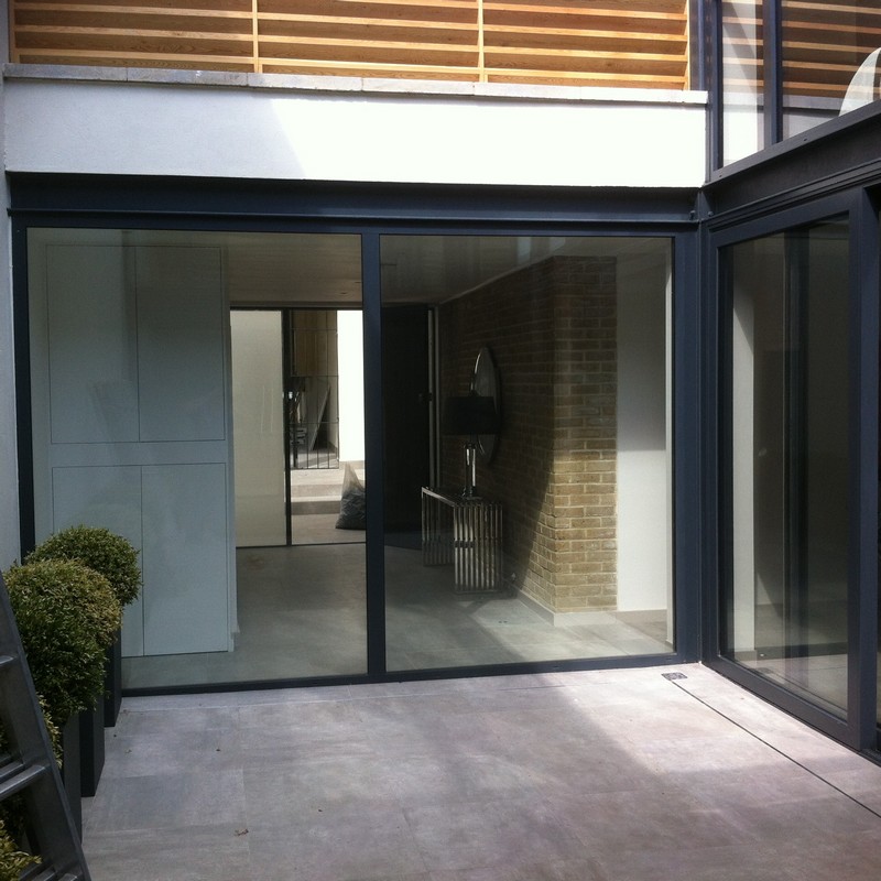 Floor-to-ceiling sliding doors opening to courtyard in Kingston upon Thames