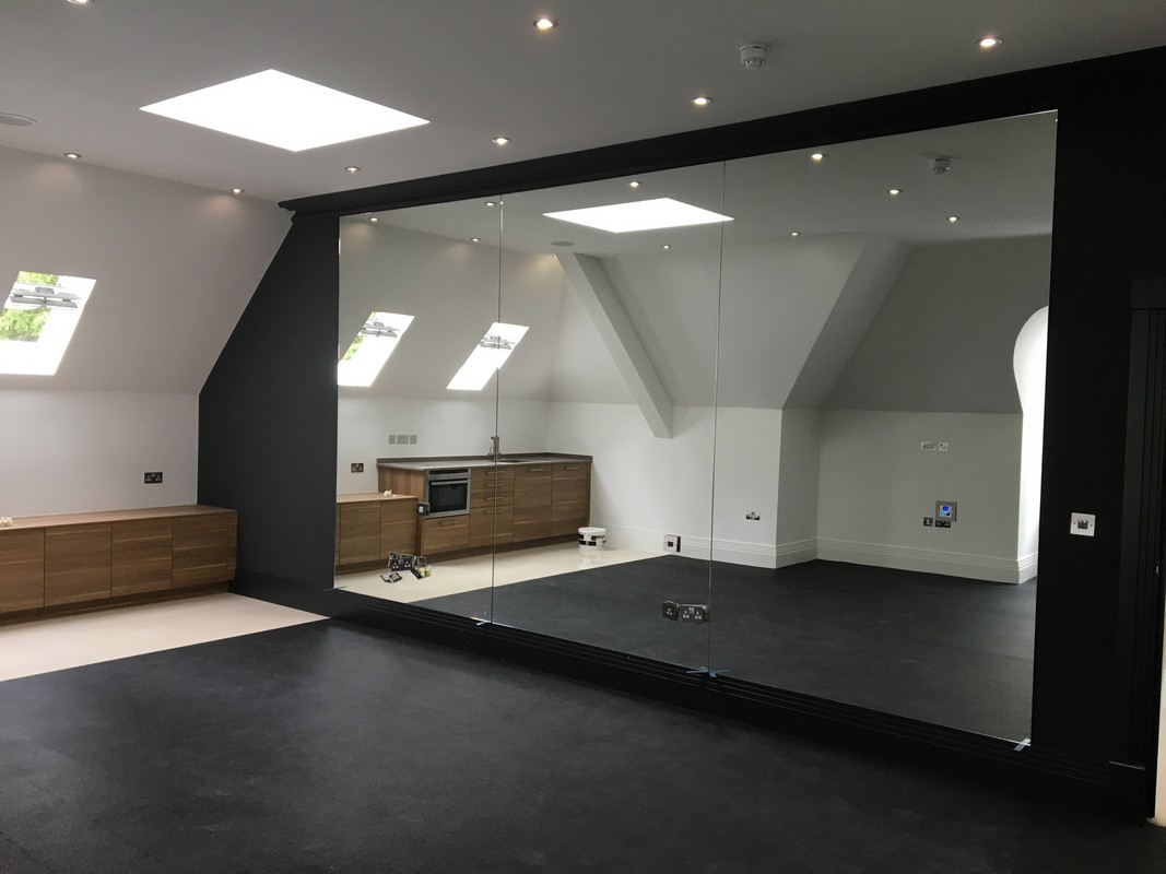 Frameless glass wall dividing loft conversion in Kingston upon Thames